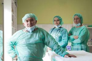 Portrait of doctors wearing uniform and preparing to doing surgical operation at the theater of hospital. Medical Concept. photo