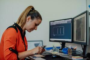 Within the heavy industry, a factory industrial engineer measures with a caliper and on a personal computer Designs a 3D model photo