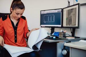 Within the heavy industry, a factory industrial engineer measures with a caliper and on a personal computer Designs a 3D model photo