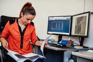 Within the heavy industry, a factory industrial engineer measures with a caliper and on a personal computer Designs a 3D model photo