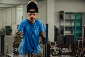 retrato de un joven ingeniero profesional de la industria pesada. trabajador con chaleco de seguridad y casco sonriendo a la cámara. en el fondo gran fábrica industrial desenfocada foto