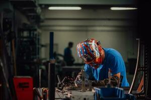 Professional Heavy Industry Welder Working Inside factory, Wears Helmet and Starts Welding. Selective Focus photo