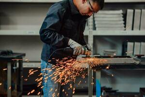 Heavy Industry Engineering Factory Interior with Industrial Worker Using Angle Grinder and Cutting a Metal Tube. Contractor in Safety Uniform and Hard Hat Manufacturing Metal Structures. photo