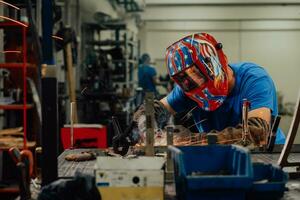 soldador profesional de la industria pesada que trabaja dentro de la fábrica, usa casco y comienza a soldar. enfoque selectivo foto