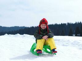 niño feliz divertirse en vacaciones de invierno en nieve fresca foto