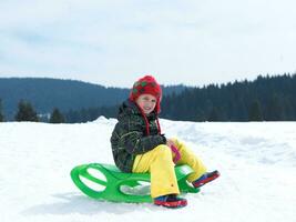 niño feliz divertirse en vacaciones de invierno en nieve fresca foto