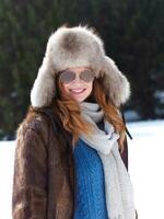 portrait of beautiful young redhair woman in snow scenery photo