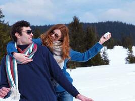 feliz pareja joven divirtiéndose en un espectáculo fresco en vacaciones de invierno foto