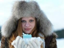portrait of  girl with gift at winter scene and snow in backgrond photo