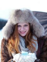 portrait of  girl with gift at winter scene and snow in backgrond photo