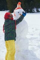 boy making snowman photo