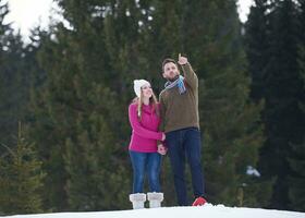 pareja divirtiéndose y caminando con raquetas de nieve foto