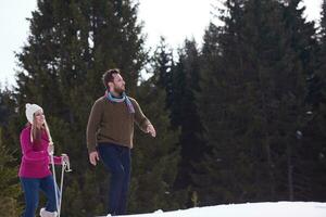 couple having fun and walking in snow shoes photo