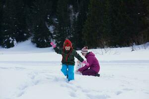 familia feliz construyendo muñeco de nieve foto