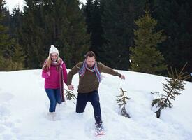 couple having fun and walking in snow shoes photo