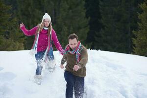 couple having fun and walking in snow shoes photo