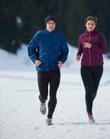 couple jogging outside on snow photo