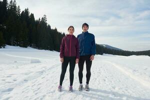 pareja trotando afuera en la nieve foto