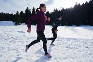 couple jogging outside on snow photo