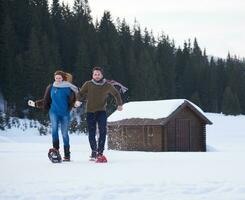 pareja divirtiéndose y caminando con raquetas de nieve foto