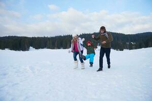 happy family playing together in snow at winter photo