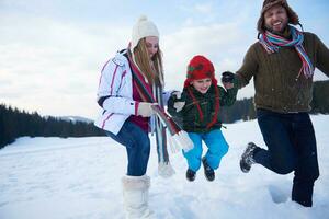 happy family playing together in snow at winter photo