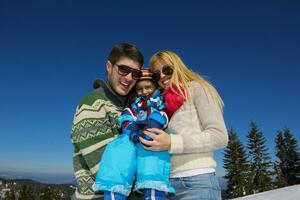 familia divirtiéndose en la nieve fresca en las vacaciones de invierno foto