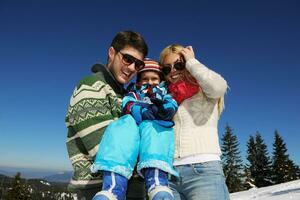 family having fun on fresh snow at winter photo