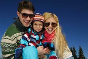 familia divirtiéndose en la nieve fresca en invierno foto