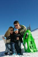 family having fun on fresh snow at winter vacation photo