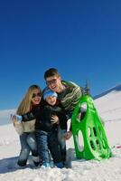 family having fun on fresh snow at winter vacation photo