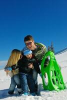 family having fun on fresh snow at winter vacation photo