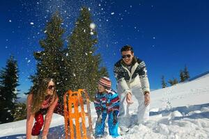 family having fun on fresh snow at winter vacation photo