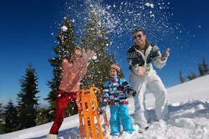 family having fun on fresh snow at winter vacation photo