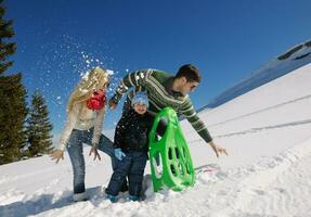 family having fun on fresh snow at winter vacation photo