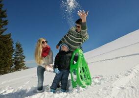 family having fun on fresh snow at winter vacation photo