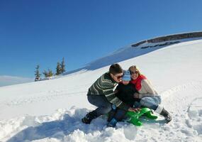 family having fun on fresh snow at winter vacation photo