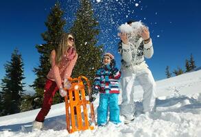 family having fun on fresh snow at winter photo