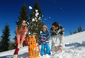 family having fun on fresh snow at winter photo