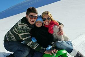 family having fun on fresh snow at winter vacation photo