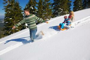 family having fun on fresh snow at winter vacation photo