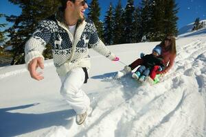 family having fun on fresh snow at winter photo