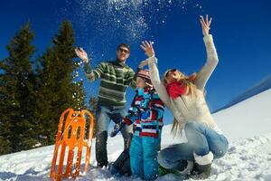 family having fun on fresh snow at winter vacation photo