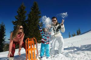 family having fun on fresh snow at winter photo