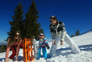 family having fun on fresh snow at winter photo