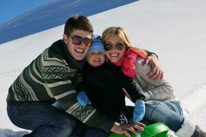 family having fun on fresh snow at winter vacation photo