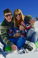 family having fun on fresh snow at winter vacation photo