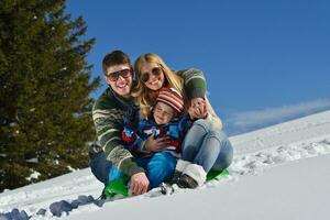 family having fun on fresh snow at winter photo