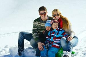 familia divirtiéndose en la nieve fresca en las vacaciones de invierno foto