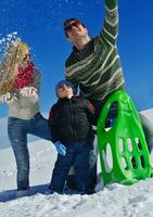 family having fun on fresh snow at winter vacation photo